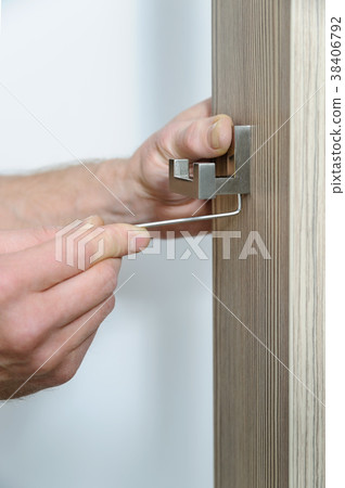 A man is installing a hook. 38406792