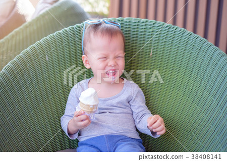 Kid in blue sunglasses eating soft serve ice cream Kid in blue sunglasses eating soft serve ice cream 38408141