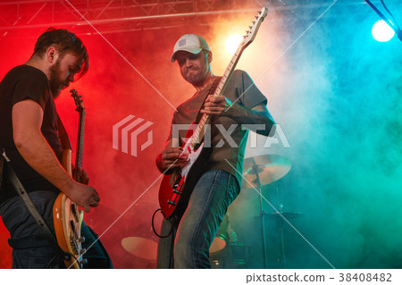 Rock band performs on stage. Guitarist, bass guitar and drums. Rock band performs on stage. Guitarist, bass guitar and drums. 38408482