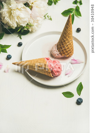 Ice cream scoops and peonies over white background Ice cream scoops and peonies over white background 38410948