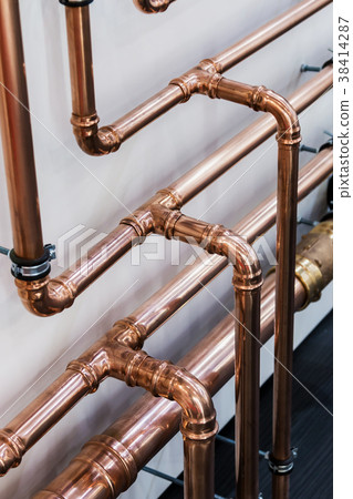 Copper pipe in front of a white wall 38414287