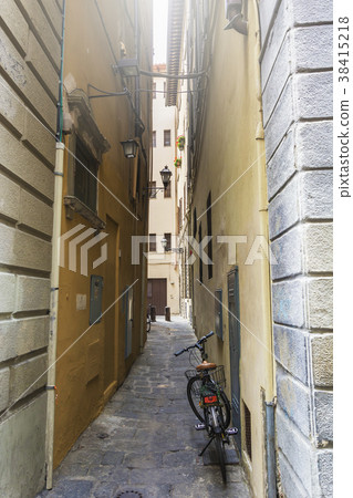 bicycle leaned on a wall of a narrow alley 38415218