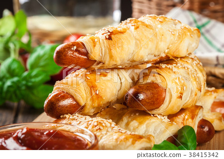 Rolled hot dog sausages baked in puff pastry 38415342