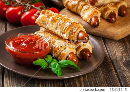 Rolled hot dog sausages baked in puff pastry Rolled hot dog sausages baked in puff pastry 38415345