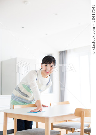 Housewife cleaning table Stock Photo by DragonImages