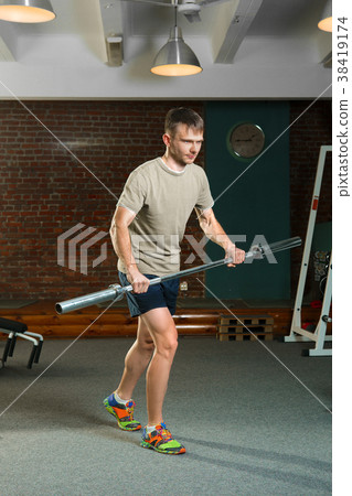 Triathlon  sportsman rowing with barbell. 38419174