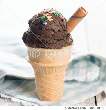 Brown ice cream in waffle cone 38424018