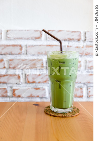 glass of iced green tea with milk on wooden table 38426265