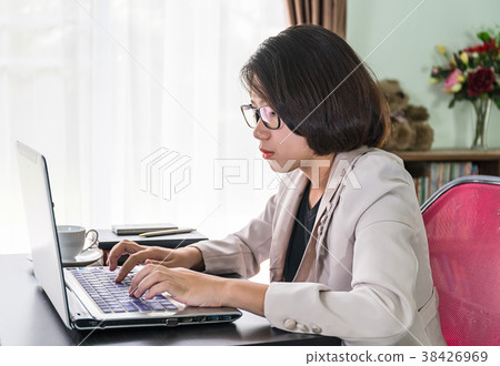 Young woman in smart casual wear working on laptop 38426969
