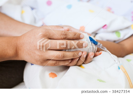 Mother hand holding sick daughter hand 38427354