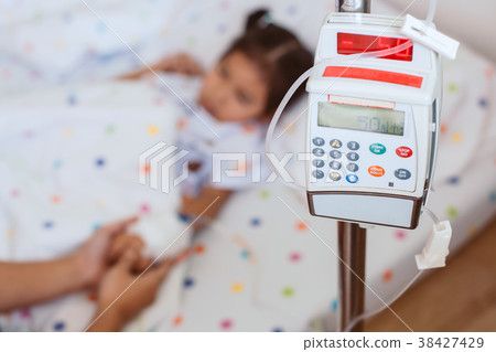 Infusion pump feeding IV drip into child patient 38427429