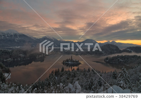 Winter sunrise at Bled lake with snow on the trees 38429769