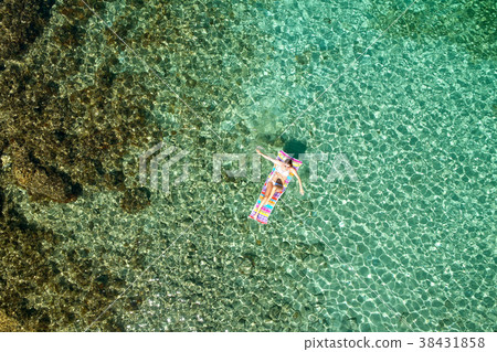 Top view of young woman in a bright bikini is swimming in the tr 38431858