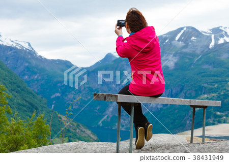 Tourist with camera looking at scenic view in mountains Norway Tourist with camera looking at scenic view in mountains Norway 38431949