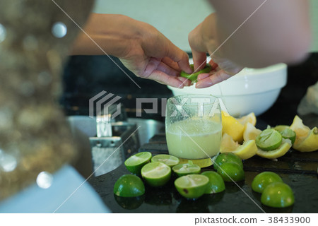 Asian lady hands squeeze green lime juice  38433900