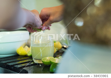 Asian lady hands squeeze green lime juice  38433901