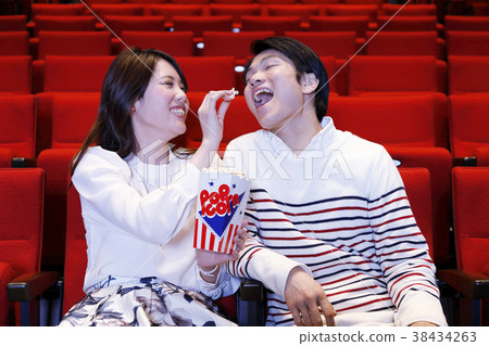 Men and women watching movies Men and women watching movies 38434263