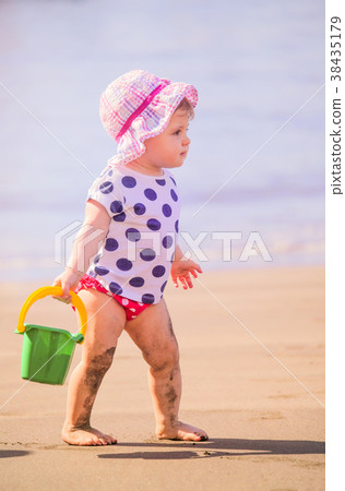 Little girl playing on the beach Little girl playing on the beach 38435179