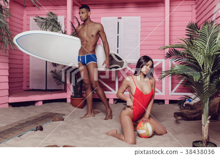 Sexy man and woman on the beach near a bungalow. 38438036