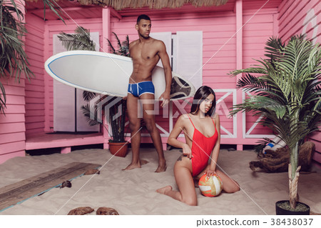 Sexy man and woman on the beach near a bungalow. 38438037