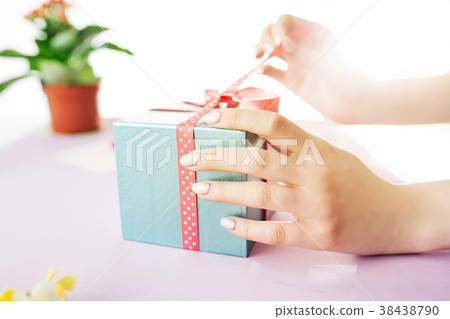Close-up of female hands holding a present. The Close-up of female hands holding a present. The 38438790