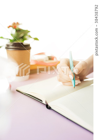 The female hands holding pen. The trendy pink desk The female hands holding pen. The trendy pink desk 38438792