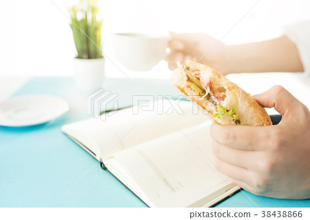 The male hands holding pen and sandwich. The The male hands holding pen and sandwich. The 38438866