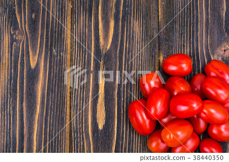 Bunch of cherry tomatoes on wooden brown boards Bunch of cherry tomatoes on wooden brown boards 38440350