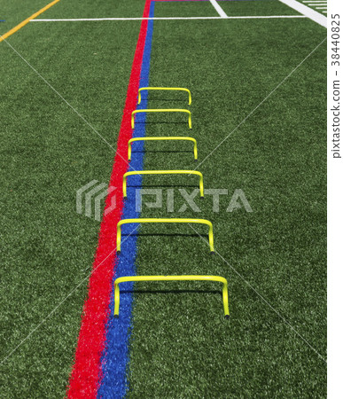 Yellow mini agility hurdles on a green turf field Yellow mini agility hurdles on a green turf field 38440825