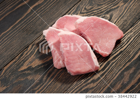 Fresh raw pork steaks on a dark wooden background. Fresh raw pork steaks on a dark wooden background. 38442922
