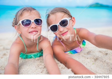 Adorable little sisters at beach during summer Adorable little sisters at beach during summer 38447805
