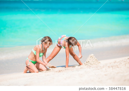 Two kids making sand castle and having fun at 38447816