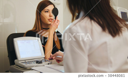 Young woman doing eye test with optometrist in Young woman doing eye test with optometrist in 38448081