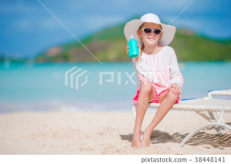 Beautiful kid with bottle of sun cream on tropical 38448141