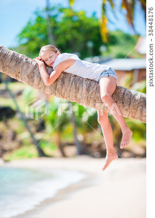 Adorable little girl at tropical beach sitting on 38448176