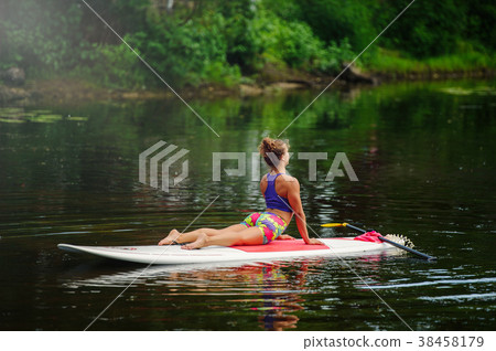 Young athletic woman doing fitness on a board Young athletic woman doing fitness on a board 38458179