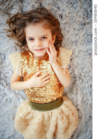 Girl in golden dress on fur 38460640