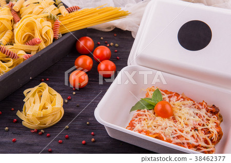 A meat lasagna with tomatoes and cheese parmesan 38462377