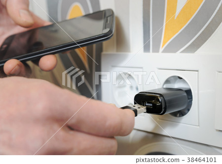 A man is charging the smartphon. 38464101