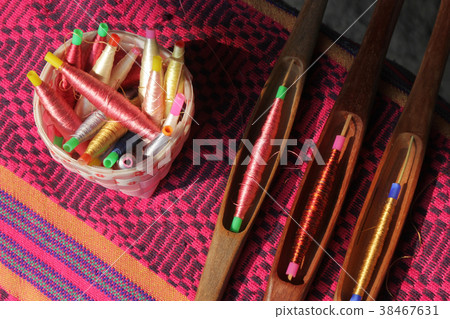 colorful bobbins in basket and wooden bobbin 38467631