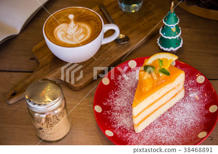 Tasty orange fruit cake on red christmas dish Tasty orange fruit cake on red christmas dish 38468891