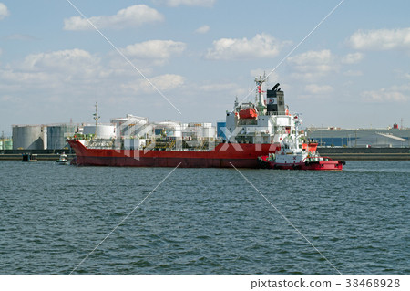 A foreign ship tanker docked with the help of a tugboat 38468928