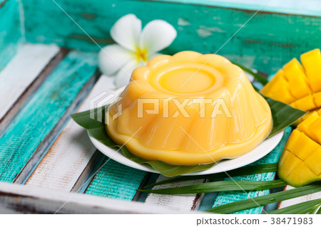 Mango pudding, jelly on white plate with palm leaf Mango pudding, jelly on white plate with palm leaf 38471983