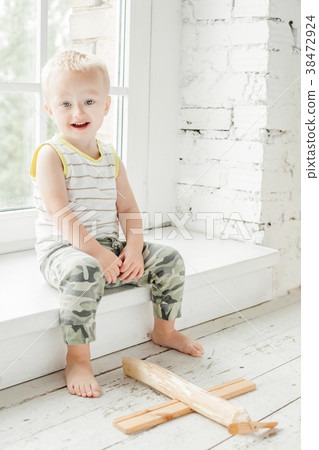 Happy child boy having fun with wooden plane toy Happy child boy having fun with wooden plane toy 38472924