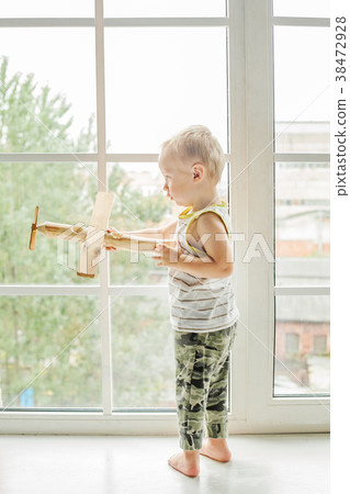 Small child boy playing with wooden plane toy Small child boy playing with wooden plane toy 38472928