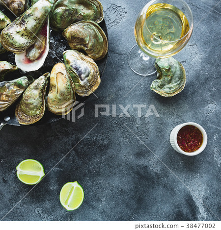 Fresh oysters platter with white wine and limes 38477002