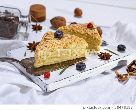 cakes Napoleon with cream on a white wooden board cakes Napoleon with cream on a white wooden board 38478192
