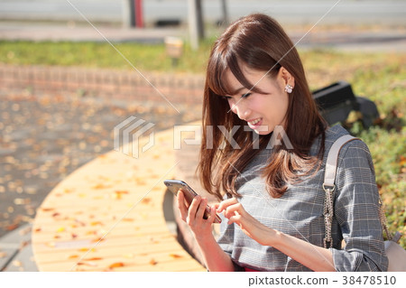 Young woman operating a mobile phone Young woman operating a mobile phone 38478510