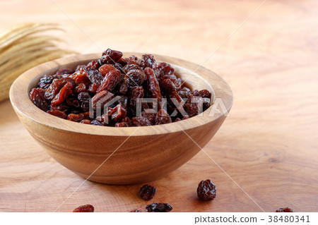 Raisin in bowl on wooden background. Raisin in bowl on wooden background. 38480341