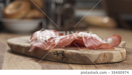 Italian prosciutto ham on wood board closeup Italian prosciutto ham on wood board closeup 38480974